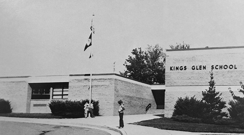 Kings Glen Elementary School Entrance, circa 1979, with safety patrol student standing on the sidwalk.