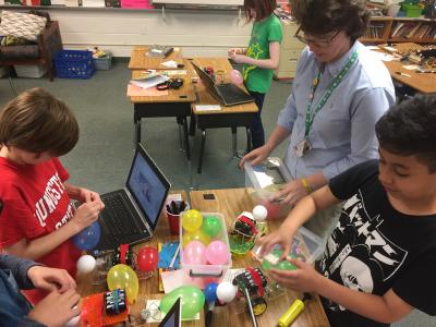 Photo of teacher and students building robots