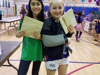 2 girls displaying certificates