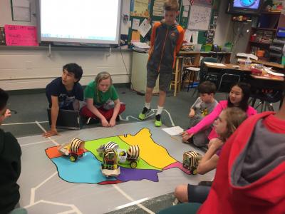 photo of students moving wagons on territory map of united states