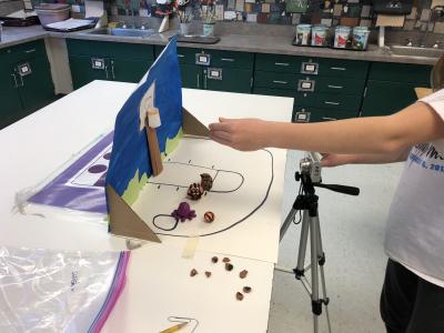 photo of student taking photos of a  mini painted set