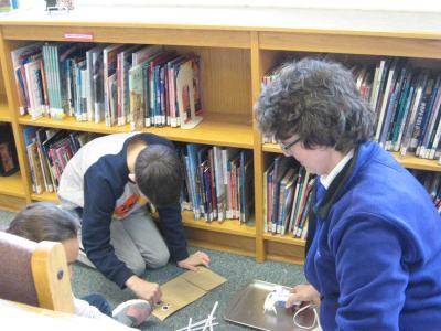 photo of students and teacher working and creating things 