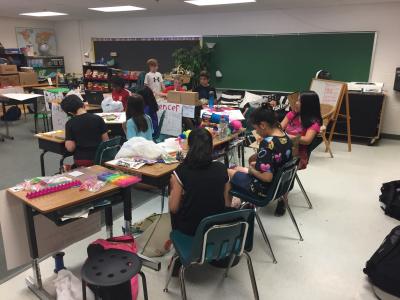 photo of classroom full of students creating items at their desks.