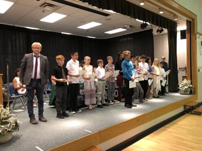 photo of students and teacher standing on stage