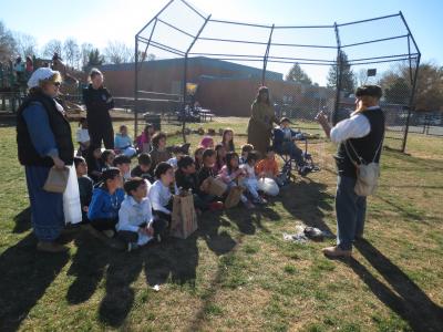 Photo of students sitting outside and learning about colonial days