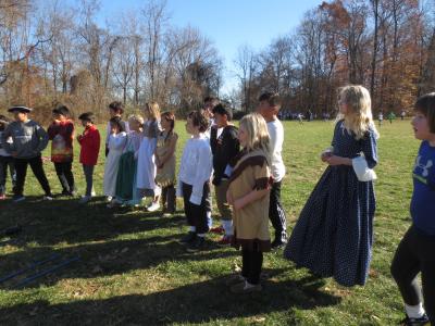 Photo of students standing outside and learning about colonial days