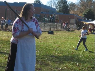 photo of teacher outside in colonial garb playing colonial games