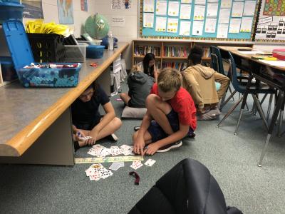 photo of students seated on the floor with cards
