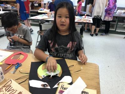 photo of student working with construction paper to create animal faces
